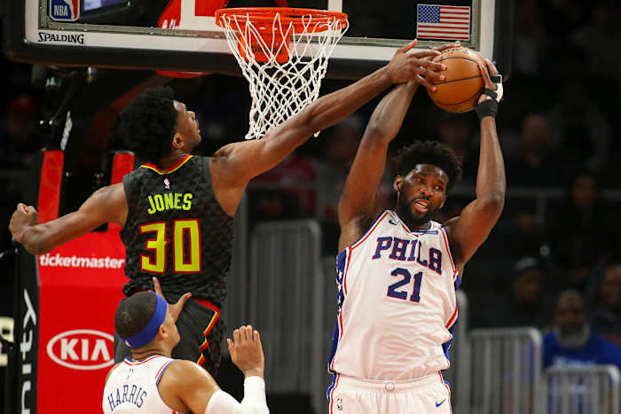 Philadelphia 76ers center Joel Embiid grabs a rebound past Atlanta Hawks center Damian Jones